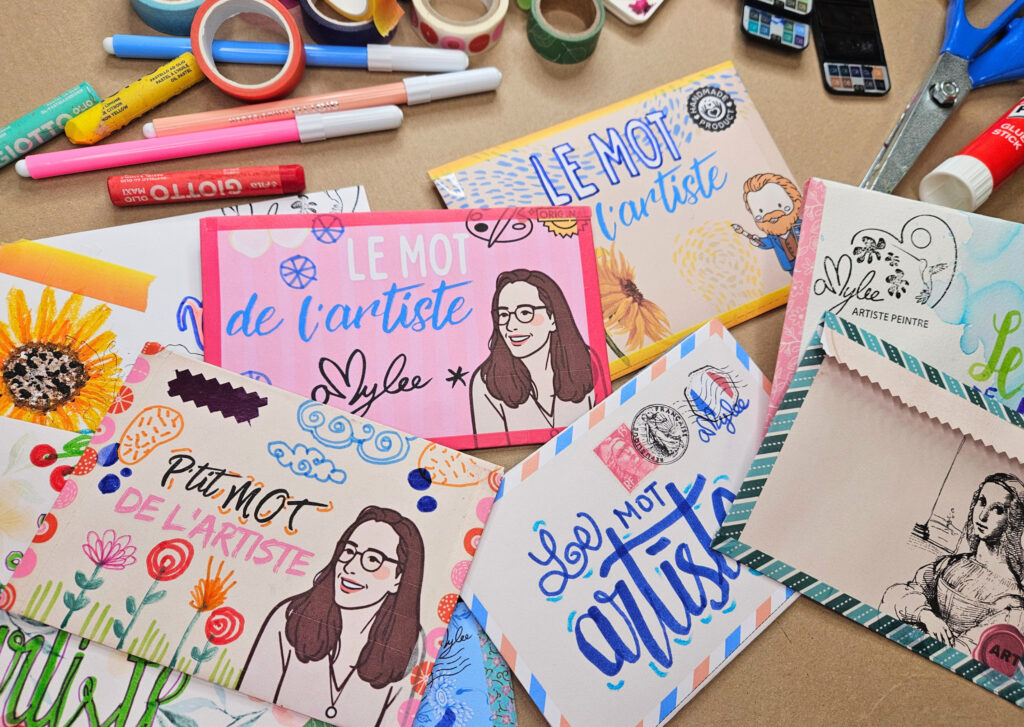 Bright colorful art sanail mails and cards with drawings and the text 'Le mot de l'artiste,' surrounded by markers, tape, and craft supplies on a table.